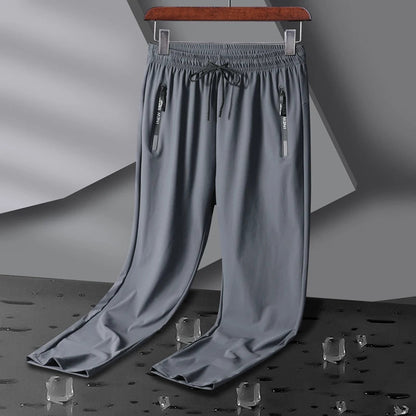 Gray men's stretch sweatpants with elastic drawstring waist, dual zip pockets, and relaxed straight-leg fit on hanger.