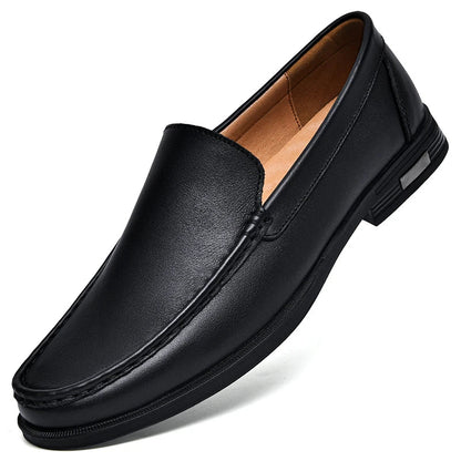 Black men's leather slip-on loafers with contrast stitching, tan interior lining, and low heel on white background