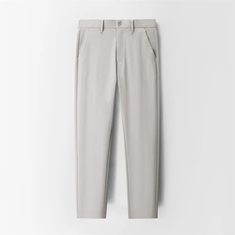 Light gray slim-fit men's dress trousers with front pockets, button closure, and tapered ankle length.