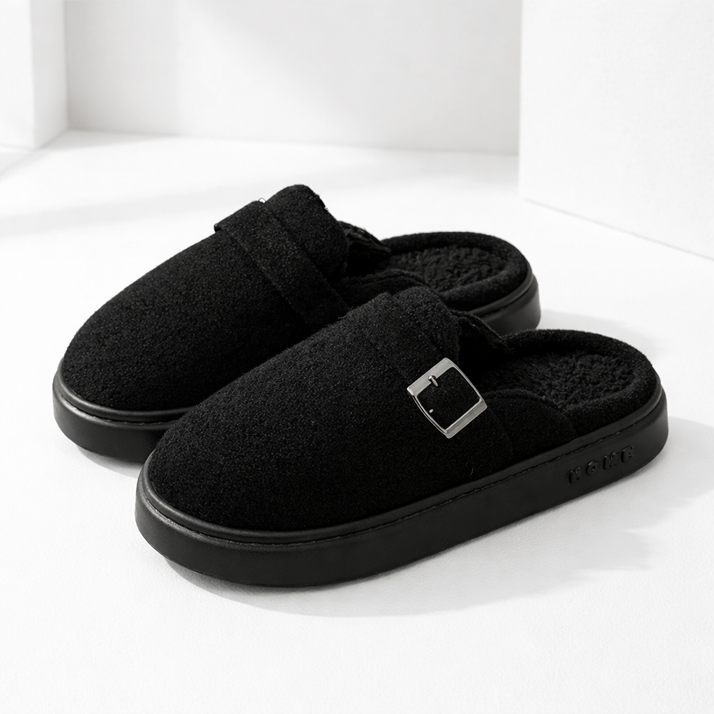 Black suede slip-on mule slippers with silver buckle detail, plush sherpa lining, and chunky rubber sole.