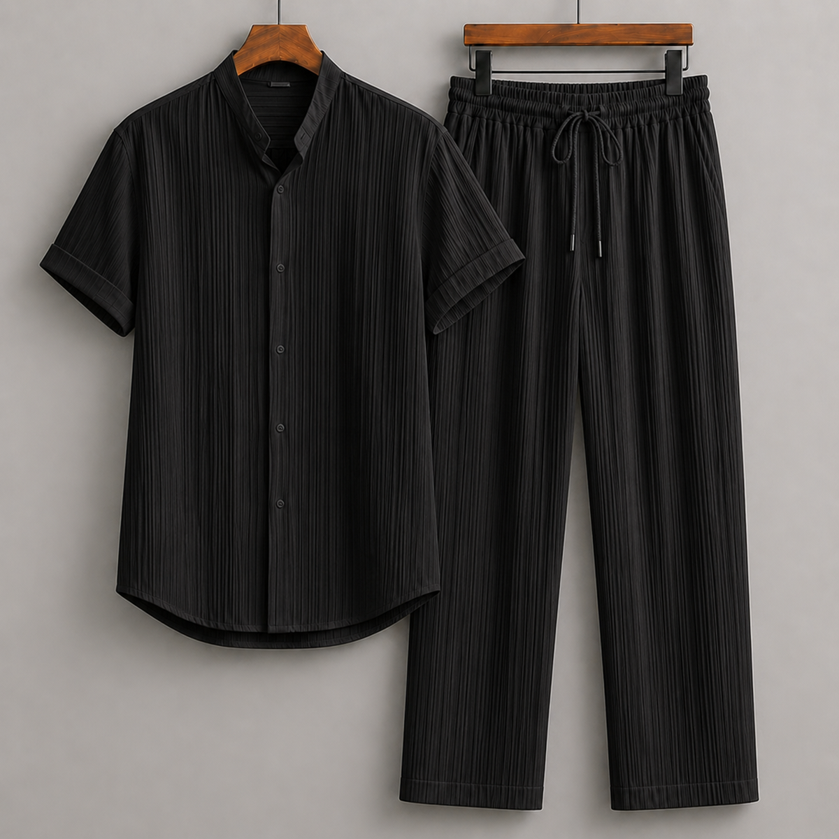 Black textured short-sleeve button-up shirt and matching wide-leg drawstring pants two-piece set for men.