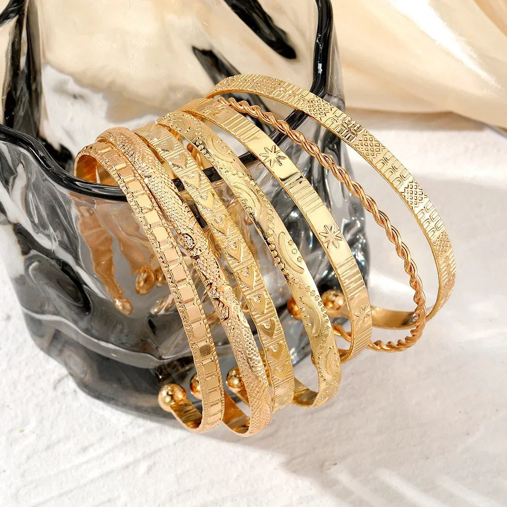 Etched gold bangle bracelet set of 6 stacked on black horse statue display stand