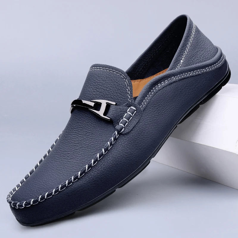 Men's navy blue leather slip-on loafers with white contrast stitching and silver metal buckle detail