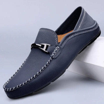 Men's navy blue leather slip-on loafers with white contrast stitching and silver metal buckle detail