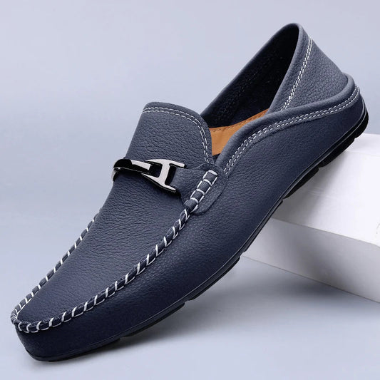 Men's navy blue leather slip-on loafers with white contrast stitching and silver metal buckle detail
