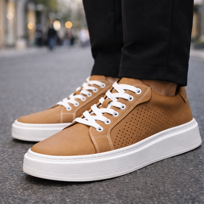 Men's tan leather lace-up sneakers with white platform sole and perforated side detail on urban street