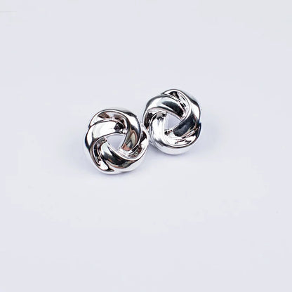 Silver twisted knot stud earrings with interlocking loops and snap closure, polished finish, shown as a pair on white background
