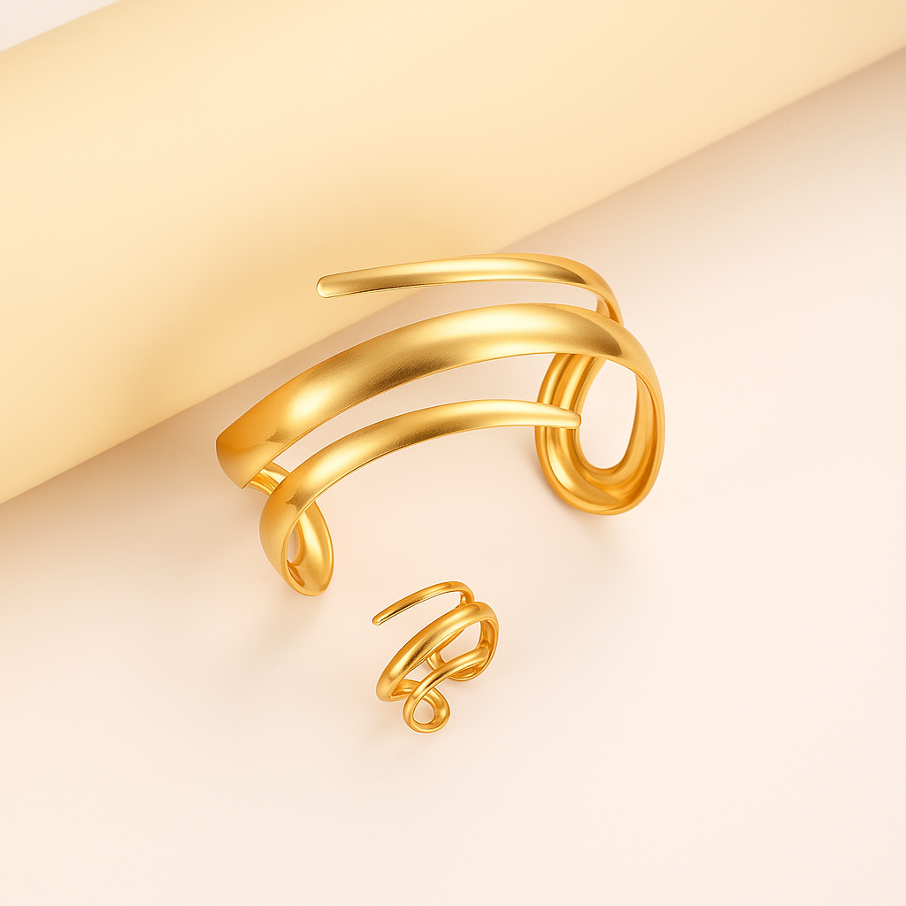 Gold-tone spiral wrap cuff bracelet and matching ring set with sleek multi-band design on neutral background