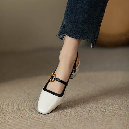 White and black leather block heel slingback pumps with gold buckle detail, paired with cropped blue jeans