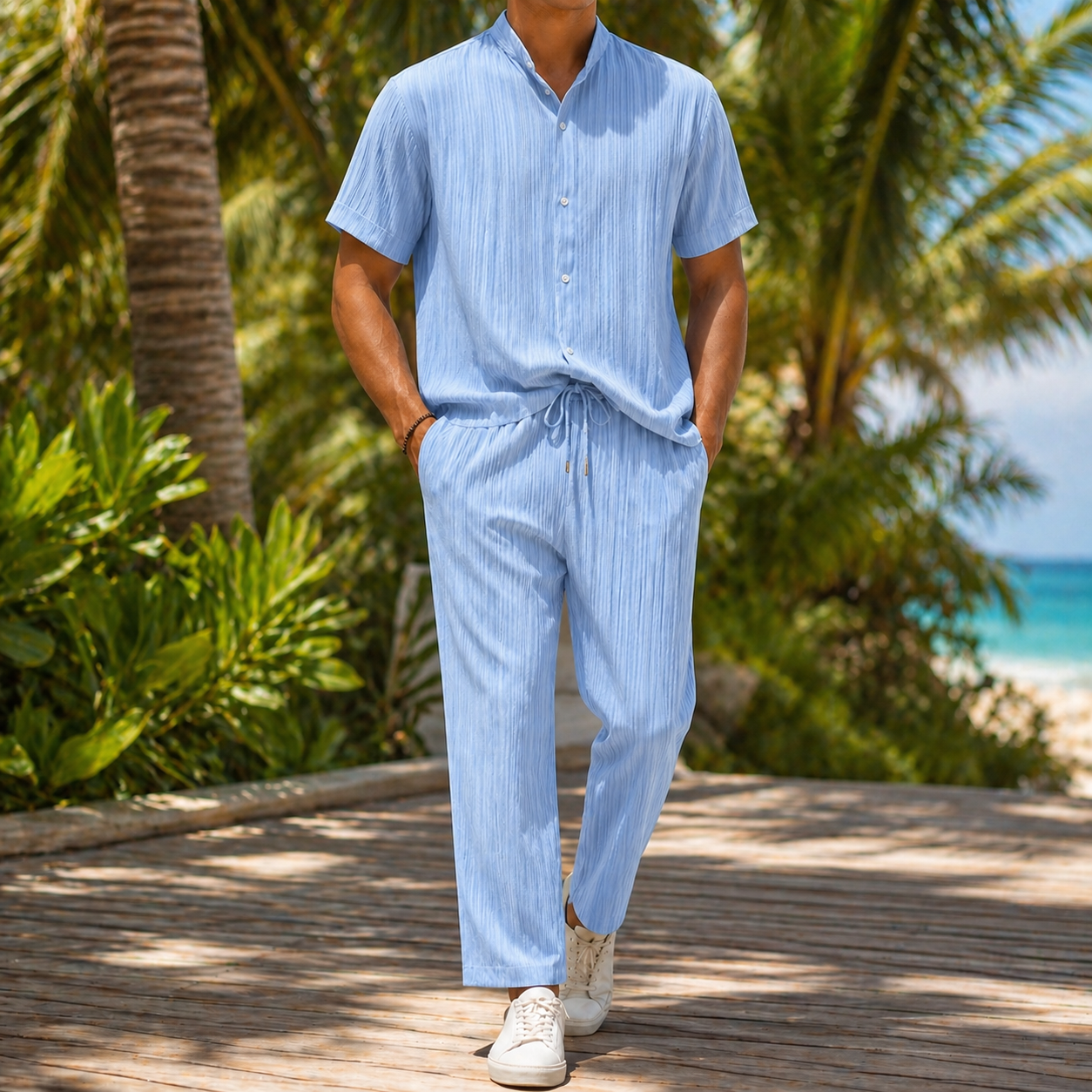 Men's light blue linen short-sleeve shirt and drawstring pants set, casual beachwear outfit on tropical boardwalk