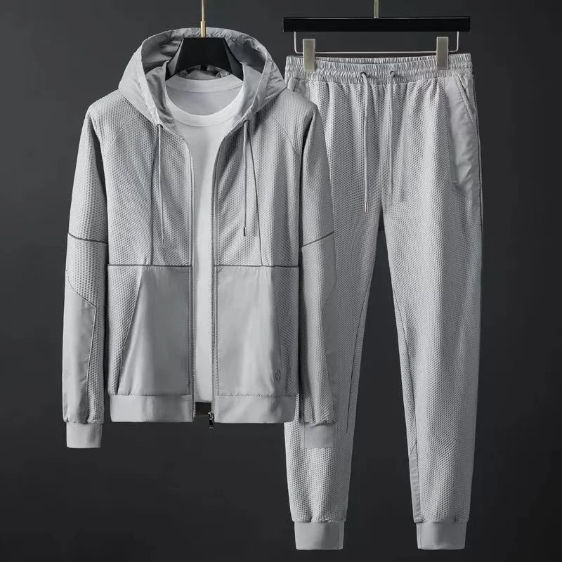 Light gray men's hooded zip-up tracksuit set with mesh texture panels, elastic waist joggers, and ribbed cuffs.