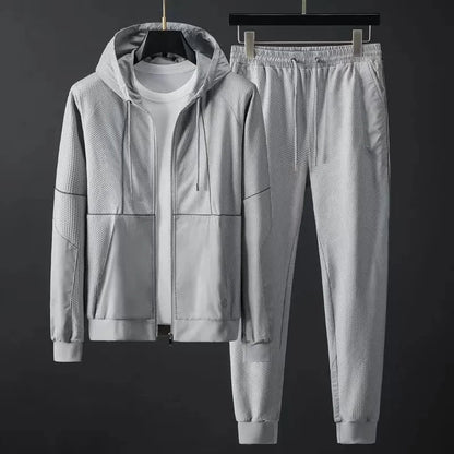Light gray men's hooded zip-up tracksuit set with mesh texture panels, elastic waist joggers, and ribbed cuffs.