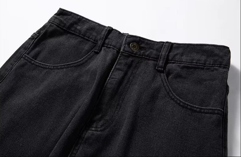 Dark gray relaxed-fit men's denim jeans showing waistband, belt loops, front pockets, and brass button closure.