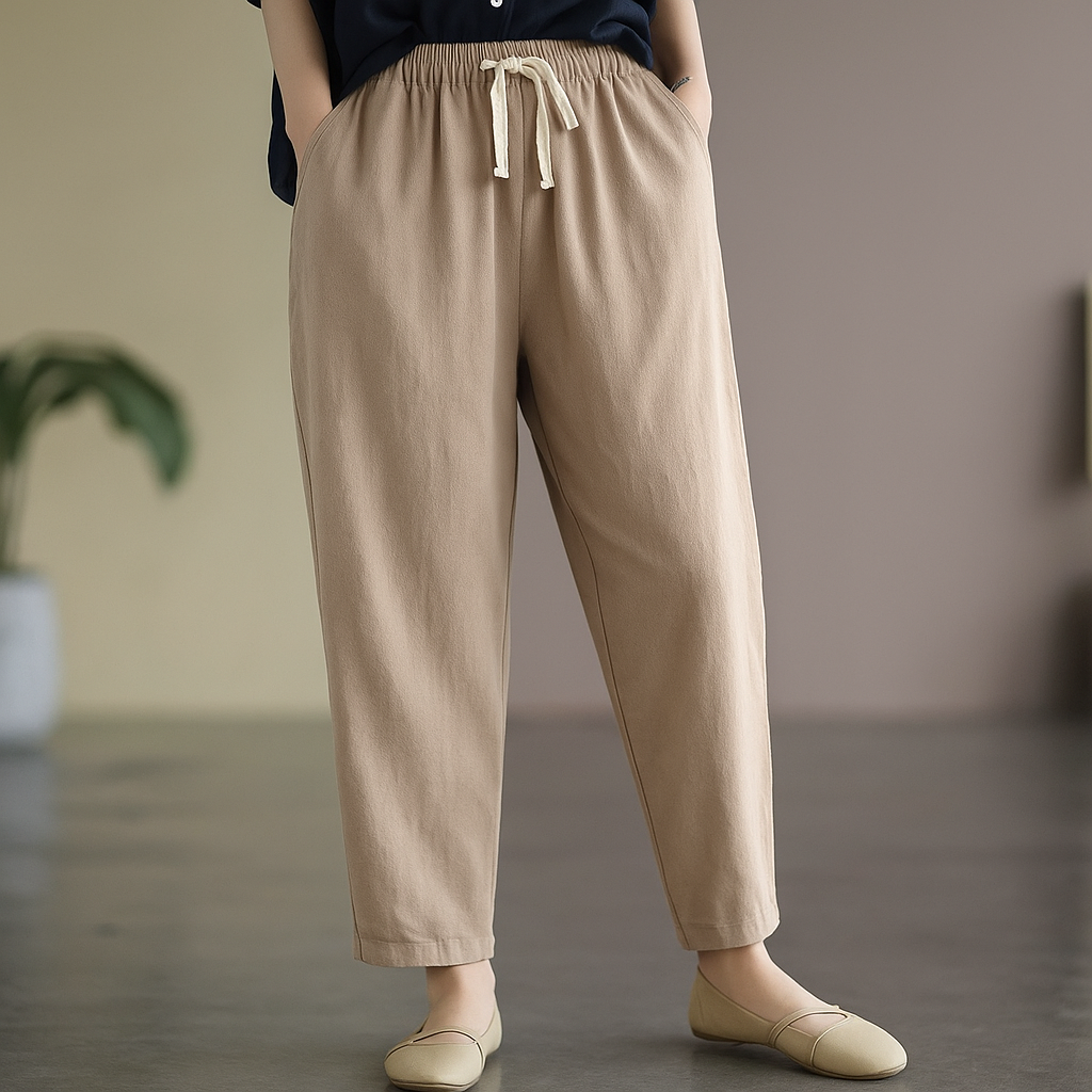 Women's khaki linen drawstring tapered pants with elastic waist, side pockets, paired with beige flats.