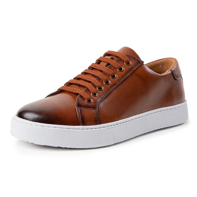 Men's tan leather lace-up sneakers with white rubber sole and bronze eyelets on white background