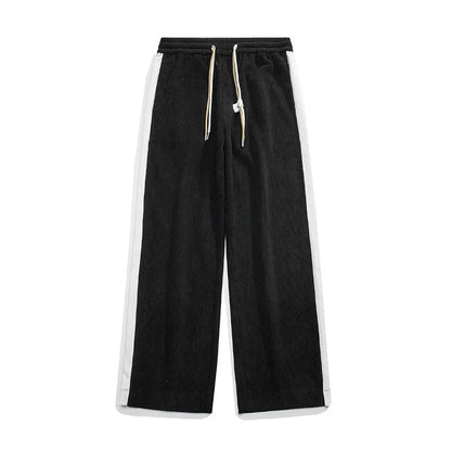 Black wide-leg corduroy joggers with white side stripes, elastic waistband, and cream drawstring closure