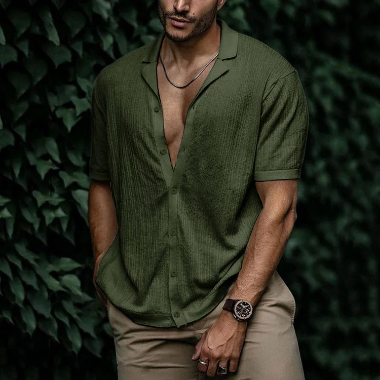 Man wearing olive green short sleeve button-down linen shirt with khaki pants and watch, posed outdoors