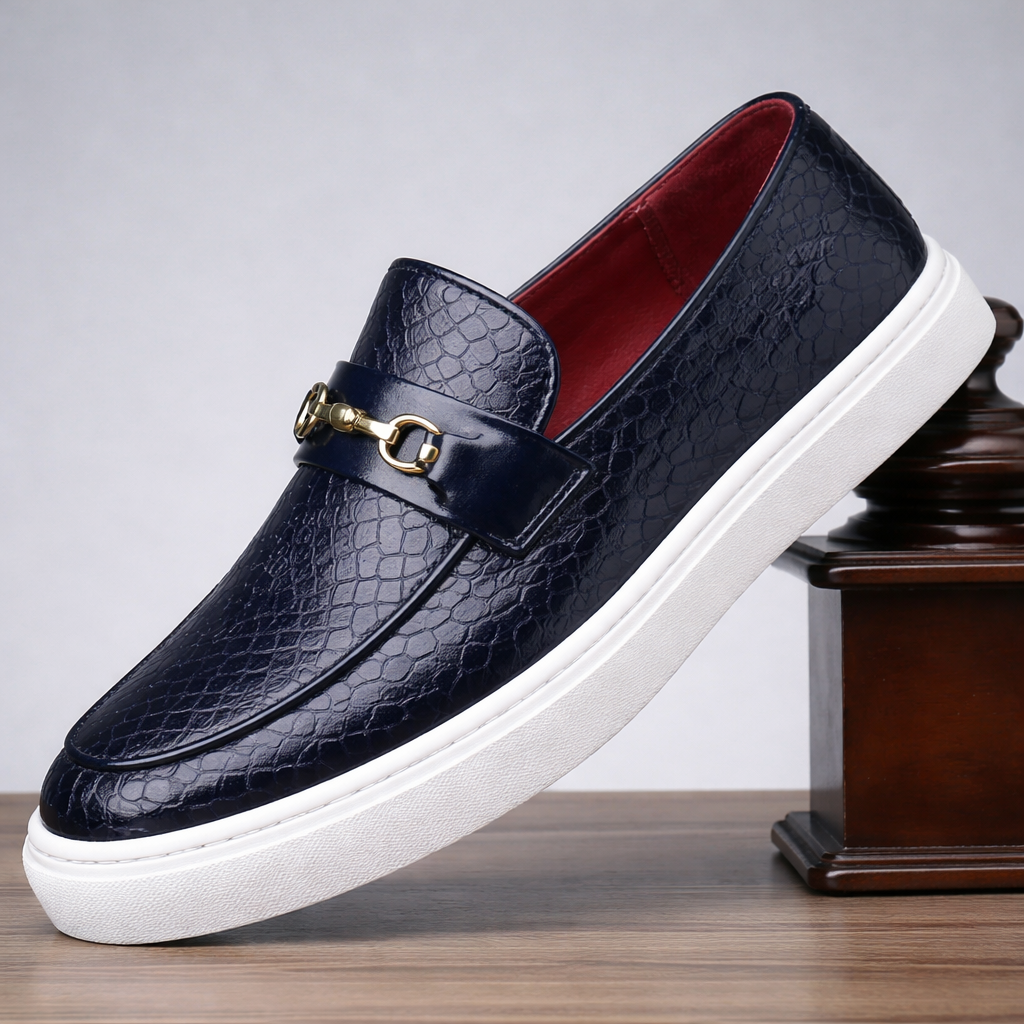 Navy blue crocodile-embossed leather slip-on loafers with gold horsebit buckle, red interior, and white rubber sole.