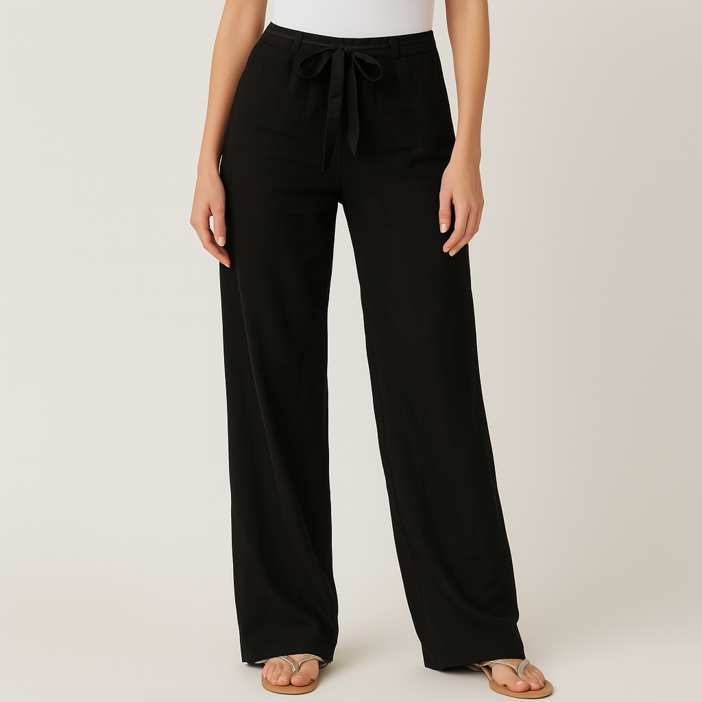 Women's black linen wide-leg pants with tie drawstring waist, worn with gold flip flops on neutral background.