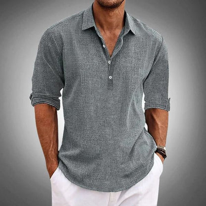 Men's gray linen henley shirt with rolled sleeves and button placket paired with white pants
