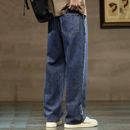 Men's wide-leg blue denim jeans with drawstring waist, worn with white sneakers and beige top, side and back view.