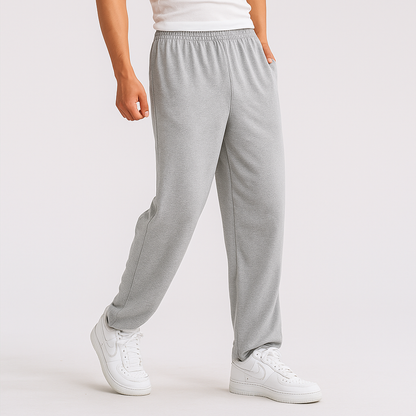 Men's gray cotton sweatpants with elastic waist and relaxed fit styled with white sneakers
