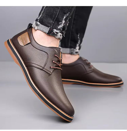 Brown leather lace-up derby shoes for men, worn with cuffed distressed jeans, featuring a pebbled texture and tan sole.