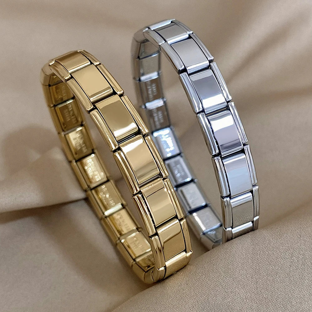 Gold and silver interlocking link chain bracelets displayed on beige satin fabric, minimalist stacking jewelry for women.