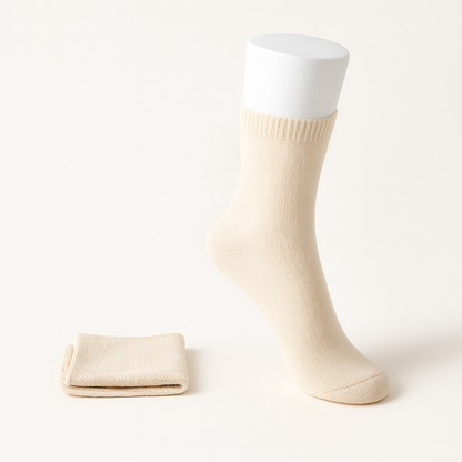 Cream beige cashmere women's socks on white display form with folded pair beside it