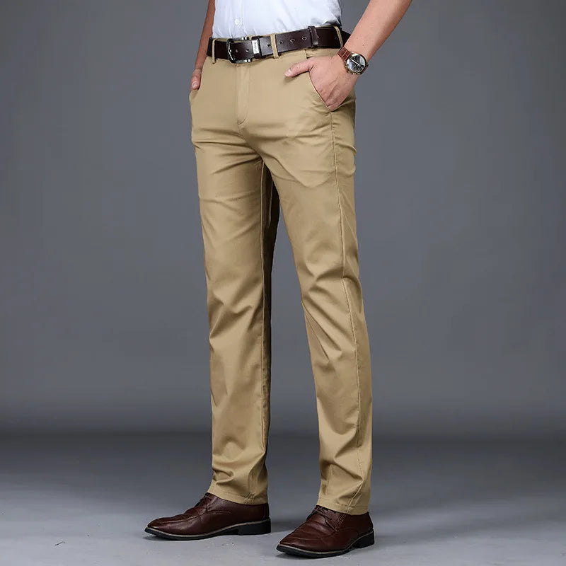 Men's slim fit khaki cotton blend dress pants with brown leather belt and dress shoes, front angle view