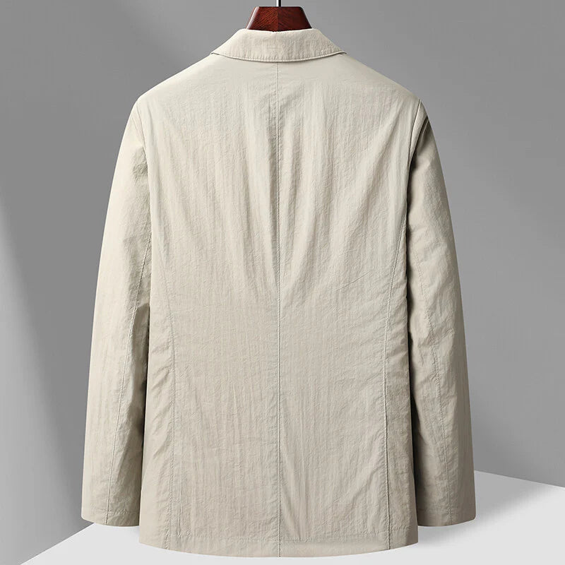 Back view of a men's beige two-button blazer with notch collar, long sleeves, and tailored fit on a wooden hanger.