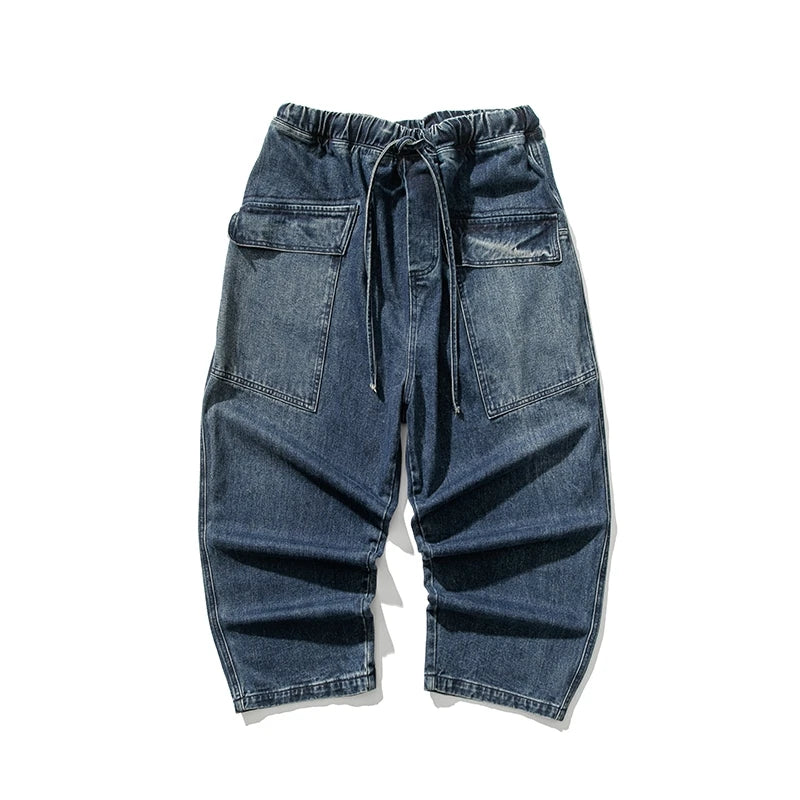 Men's wide-leg blue denim jeans with elastic drawstring waist, large cargo pockets, and relaxed fit silhouette