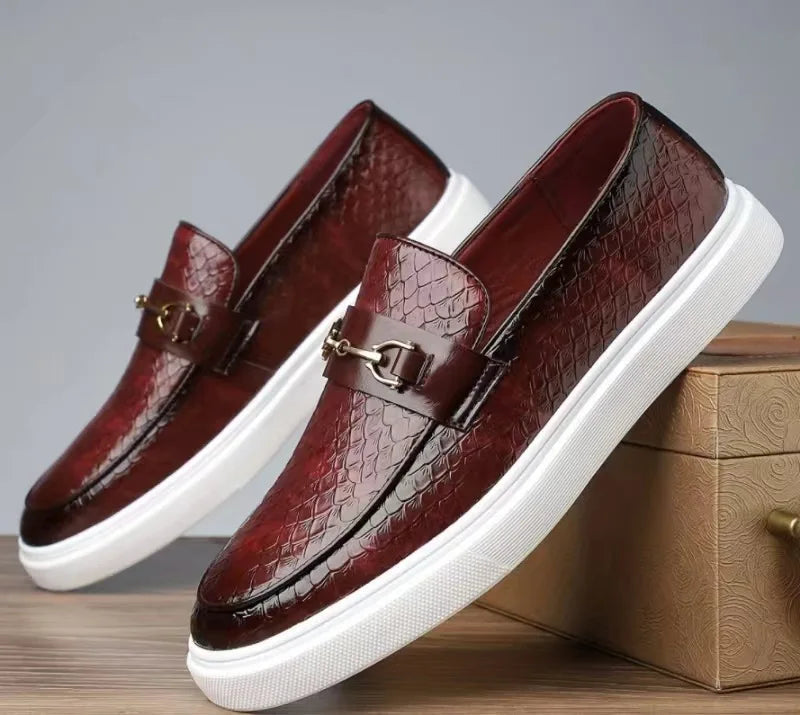 Burgundy crocodile-embossed leather slip-on loafers with gold horsebit buckle and white rubber sole for men