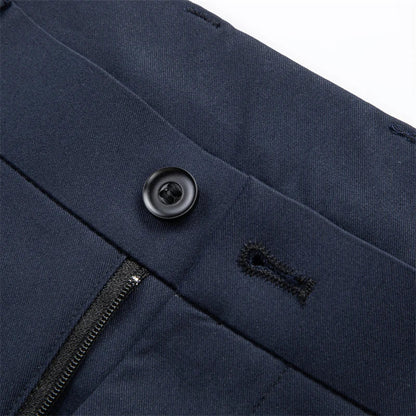 Navy blue slim-fit men's dress trousers close-up showing black button, buttonhole, and zipper fly detail