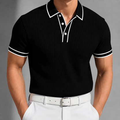 Men's black ribbed knit polo shirt with white contrast collar, button placket, and sleeve cuffs, paired with white pants.