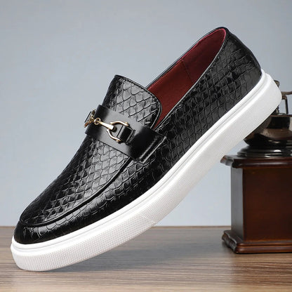 Black embossed leather men's slip-on loafers with gold horsebit buckle, red interior lining, and white rubber sole.