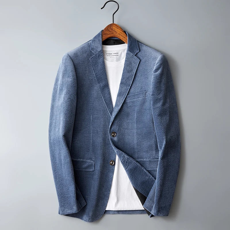Men's blue corduroy blazer jacket with two buttons on wooden hanger against gray background