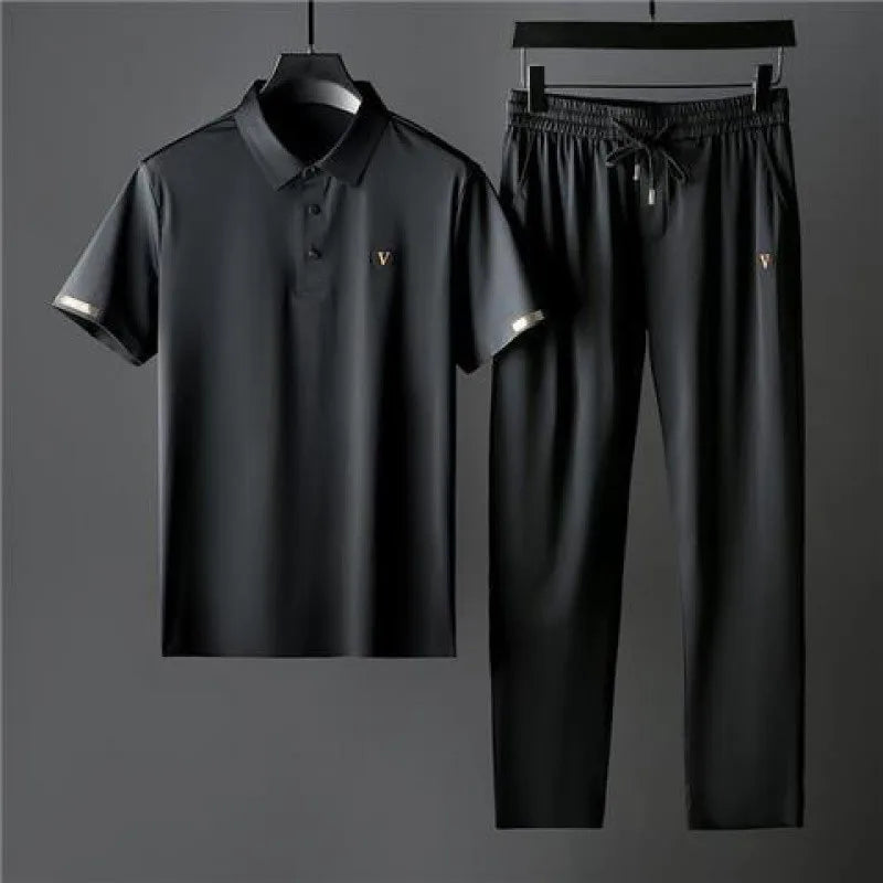 Black men's Viero polo shirt and drawstring pants set with gold V logo accents on chest and sleeves, displayed on hangers.