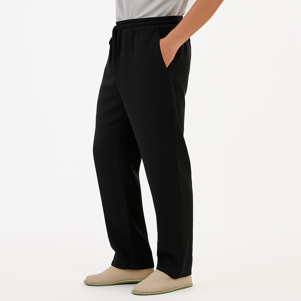 Man wearing black cotton drawstring pants with side pockets, paired with a gray tee and beige slip-on shoes.