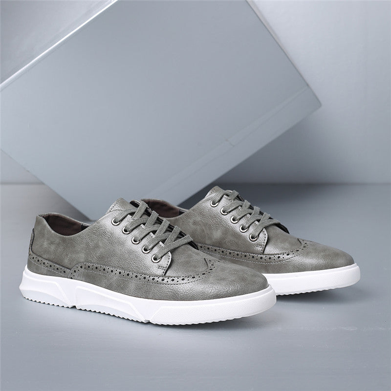 Gray men's brogue leather lace-up sneakers with white rubber sole and decorative perforated detailing