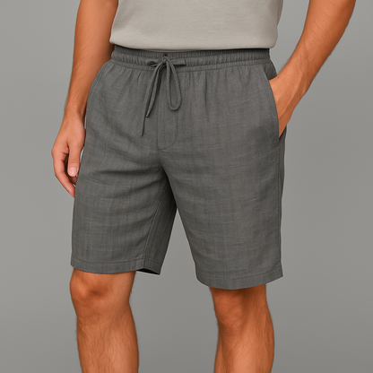 Men's gray linen drawstring shorts with elastic waistband and side pockets, worn with a light gray t-shirt.