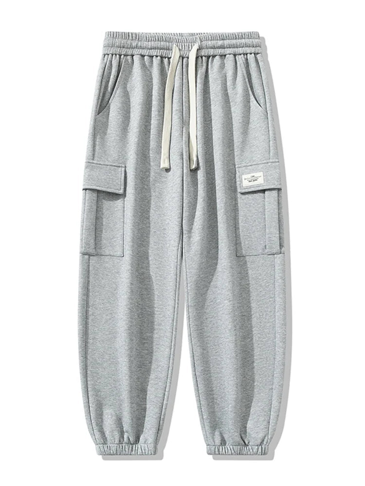 Gray men's cargo jogger pants with elastic drawstring waist, side pockets, cargo flap pockets, and ribbed cuffed ankles.