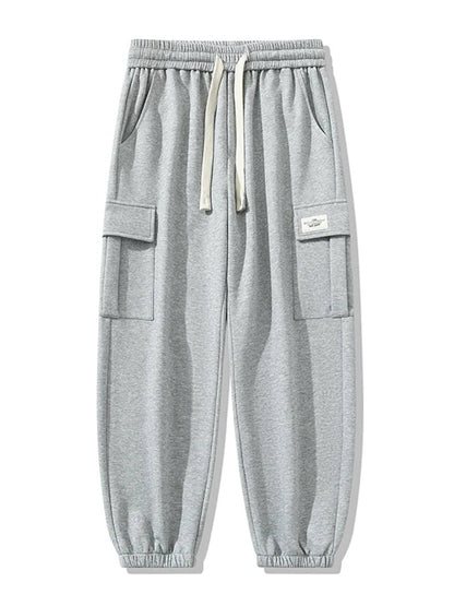 Gray men's cargo jogger pants with elastic drawstring waist, side pockets, cargo flap pockets, and ribbed cuffed ankles.