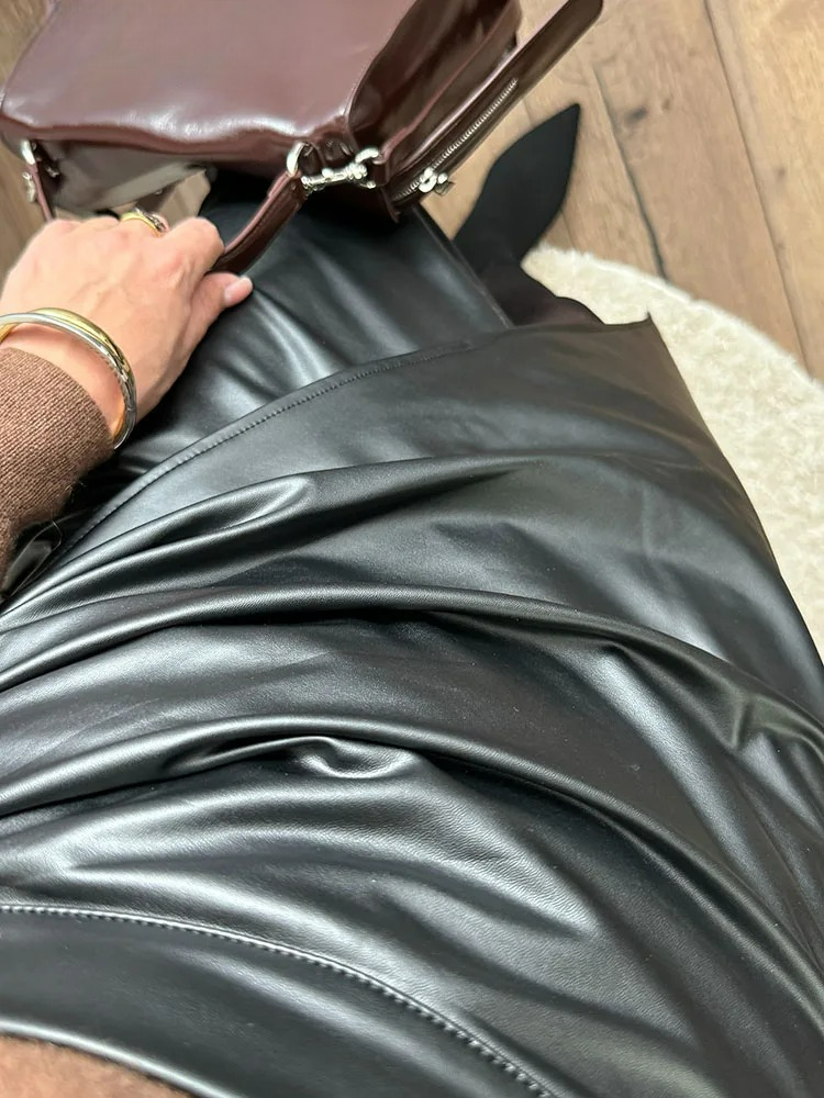 Black vegan leather wrap midi skirt styled with a burgundy leather handbag and gold bangle bracelet