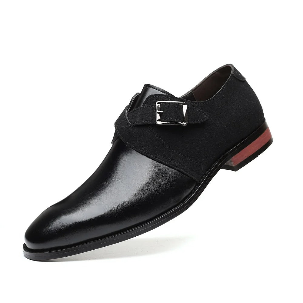 Black men's leather and suede monk strap loafer with silver buckle and red wooden heel on white background