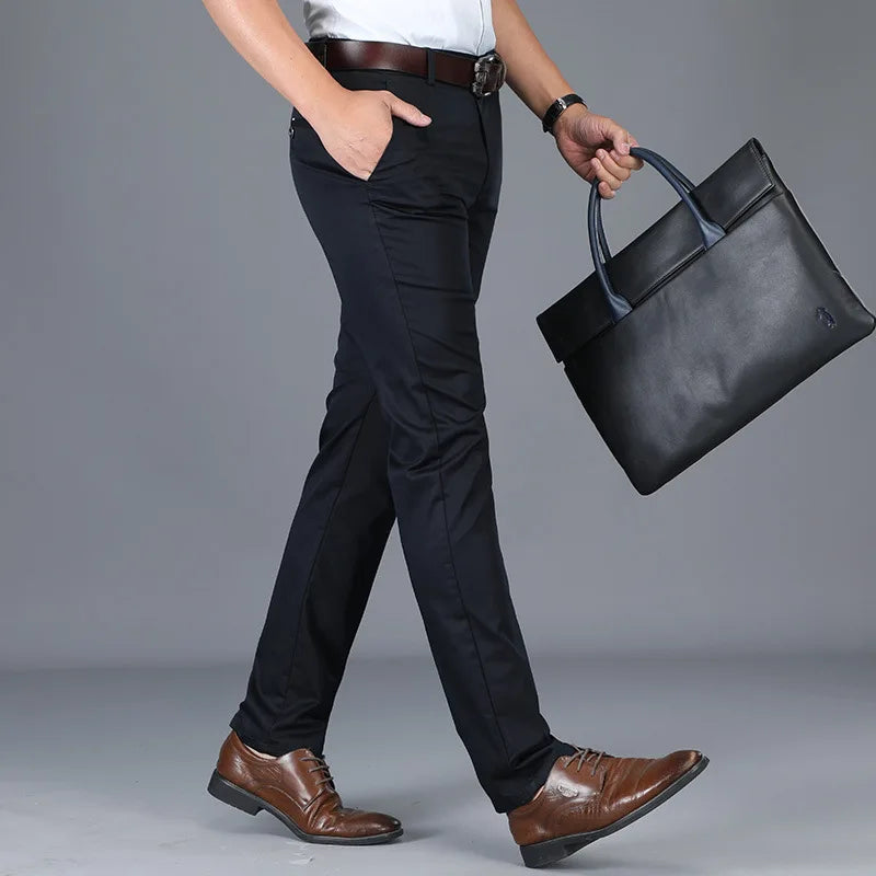 Man wearing slim fit navy dress pants with brown leather oxford shoes and belt, carrying black briefcase