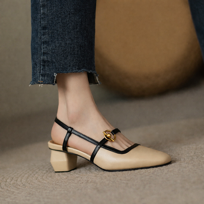 Beige leather block heel slingback pumps with black straps and gold circular buckle, worn with cropped jeans