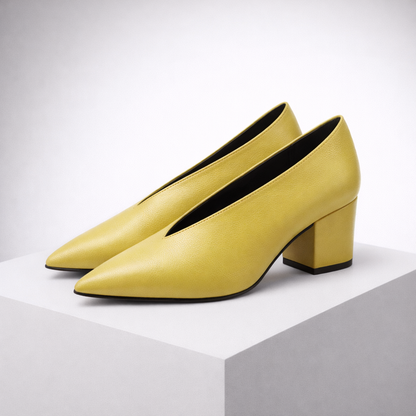 Yellow women's Italian leather block heel pumps with pointed toe and V-cut opening on white display block