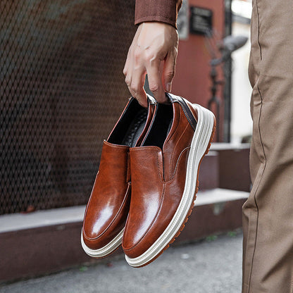 Brown leather slip-on loafers with white platform sole held in hand, showing sleek pointed toe and elastic side panels