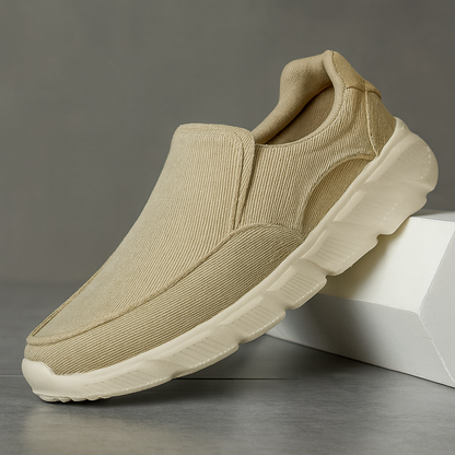 Beige corduroy slip-on sneakers for men with white chunky sole and ribbed texture upper displayed on white block
